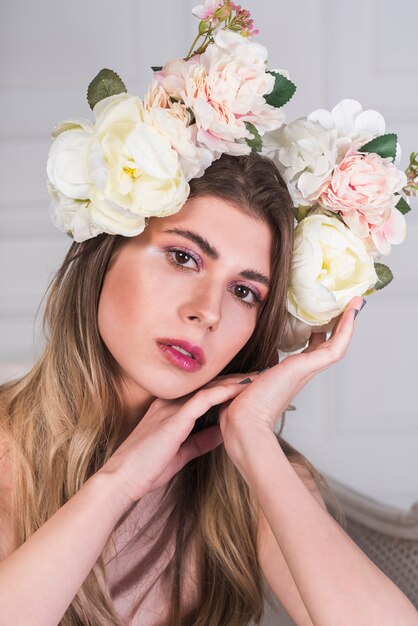 Joven dama romántica con guirnalda de flores hermosas