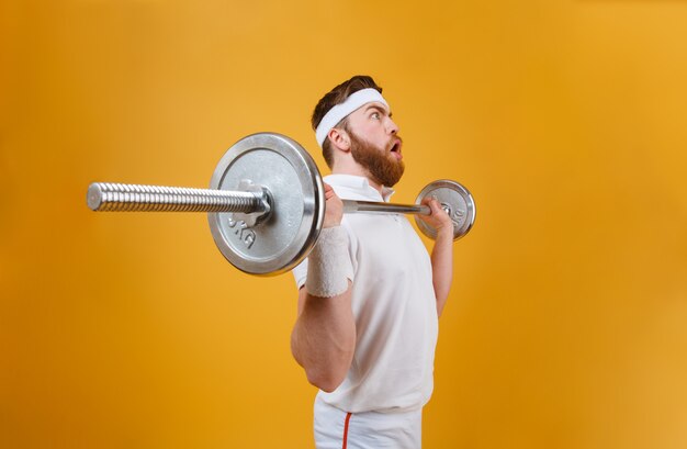 Joven deportista concentrado hacer ejercicios deportivos con barra