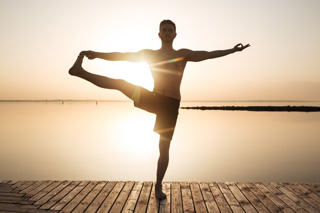 Joven deportista concentrado hacer ejercicios de meditación y yoga