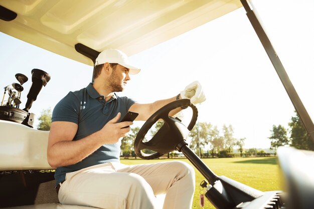 Joven deportista conduciendo un carrito de golf