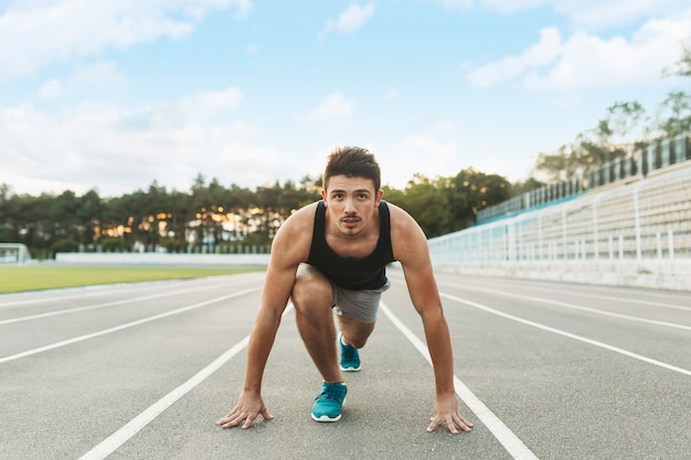 Joven deportista está listo para correr al aire libre por la mañana.