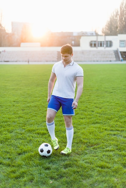 Foto gratuita joven deportista tocando la pelota con bota