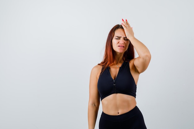 Foto gratuita joven deportiva con cabello largo con dolor de cabeza