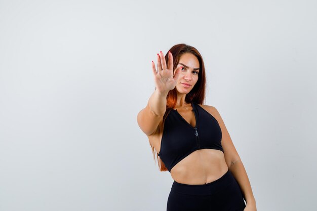 Joven deportiva con cabello largo mostrando gesto de parada