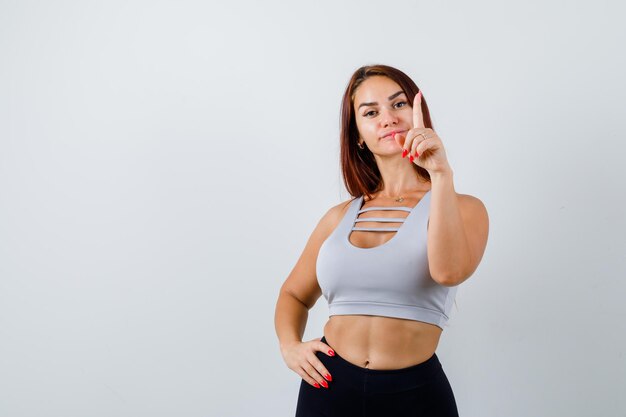 Joven deportiva con cabello largo en un top gris