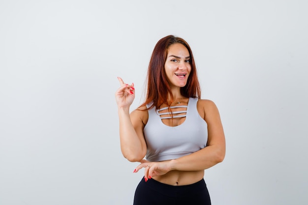 Joven deportiva con cabello largo en un top gris