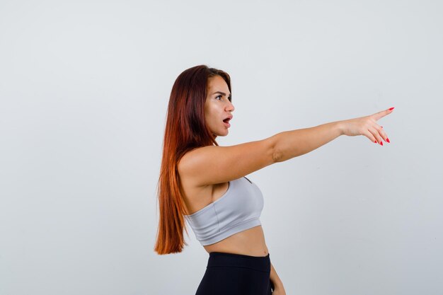 Foto gratuita joven deportiva con cabello largo en un top gris