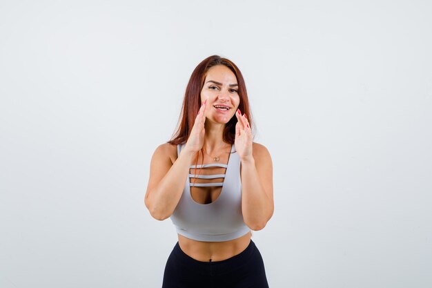 Joven deportiva con cabello largo en un top gris