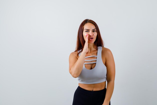 Joven deportiva con cabello largo en un top gris