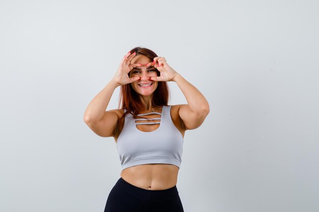 Joven deportiva con cabello largo en un top gris