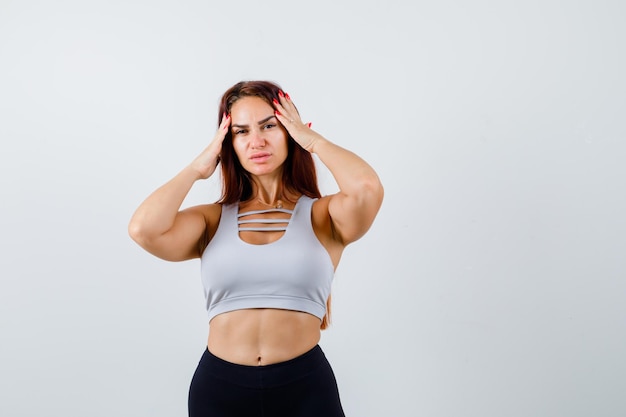 Joven deportiva con cabello largo en un top gris