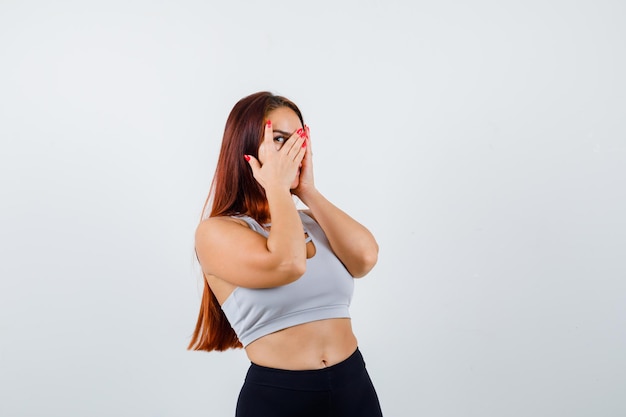 Joven deportiva con cabello largo en un top gris