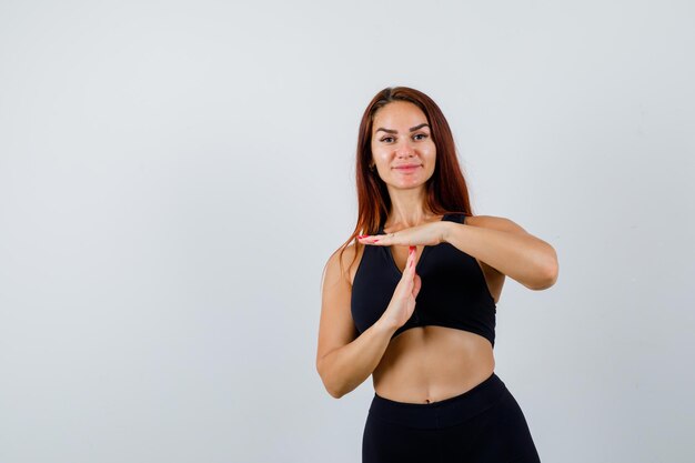 Foto gratuita joven deportiva con cabello largo en un top negro