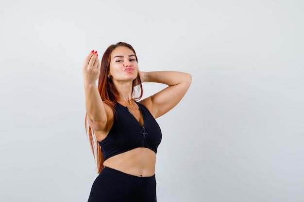 Joven deportiva con cabello largo en un top negro