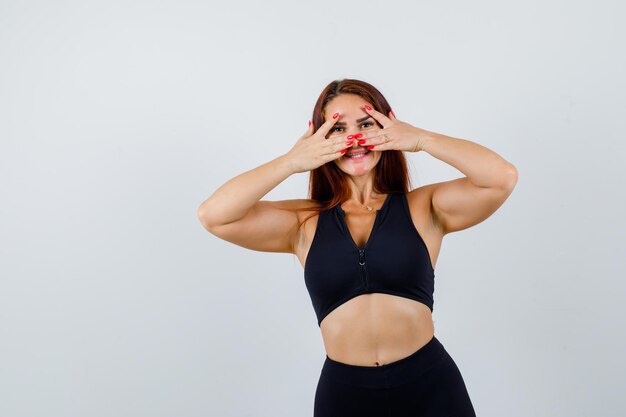 Foto gratuita joven deportiva con cabello largo en un top negro