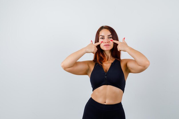 Foto gratuita joven deportiva con cabello largo en un top negro