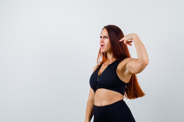 Joven deportiva con cabello largo en un top negro