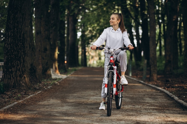 Joven deportiva montando bicicleta en el parque