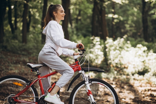 Joven deportiva montando bicicleta en el parque