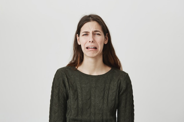 Joven deprimida llorando y sollozando, se siente triste