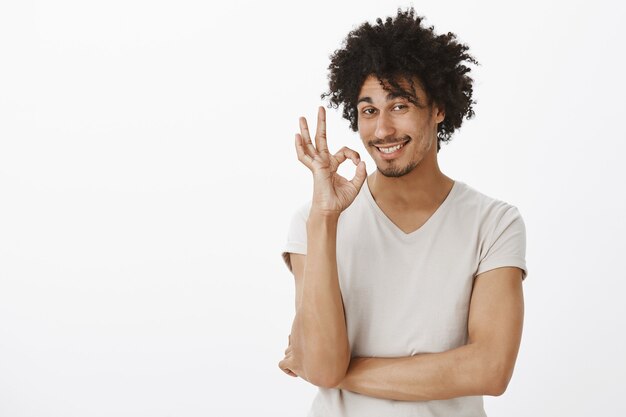 Un joven descarado y sonriente dice que no hay problema, bien hecho. el hombre alaba la buena elección y muestra un gesto bien satisfecho