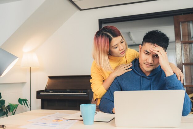 Joven destacó a una pareja asiática administrando las finanzas, revisando sus cuentas bancarias usando una computadora portátil