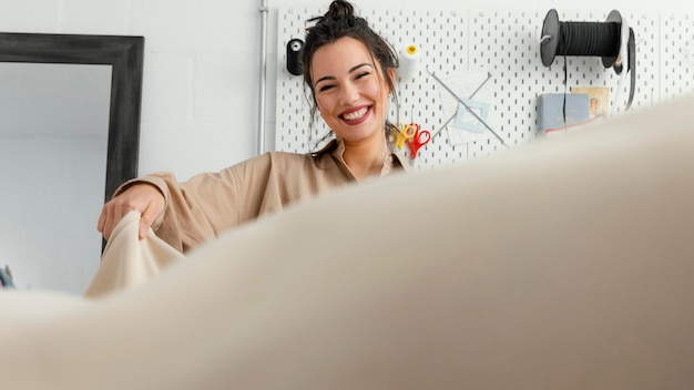 Joven diseñadora de moda trabajando sola en su taller