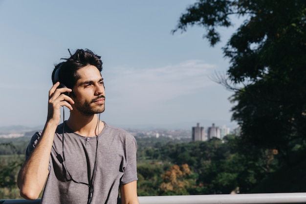 Joven disfrutando de la música en el parque