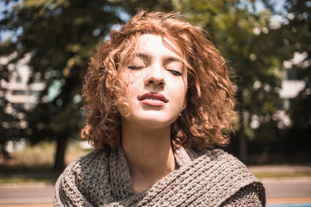 Joven disfrutando del viento en el parque