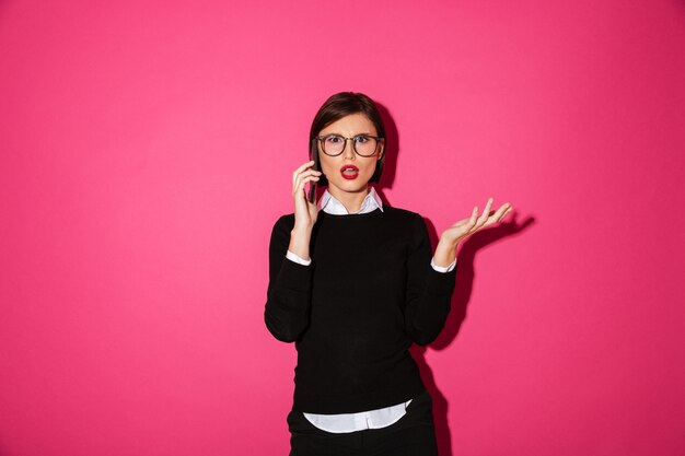 Foto gratuita joven disgustada hablando por teléfono inteligente aislado