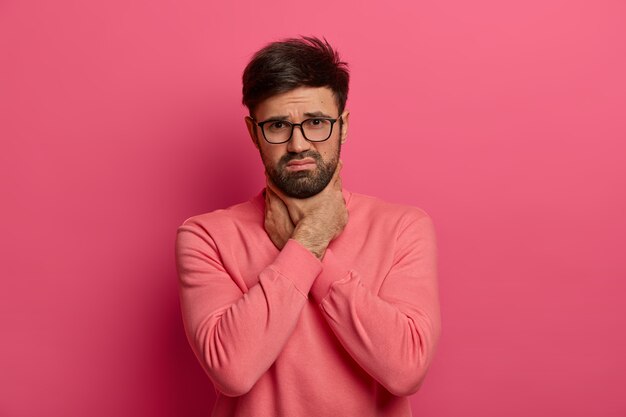 Joven disgustado sufre de asfixia, toca el cuello con las manos y se ahoga