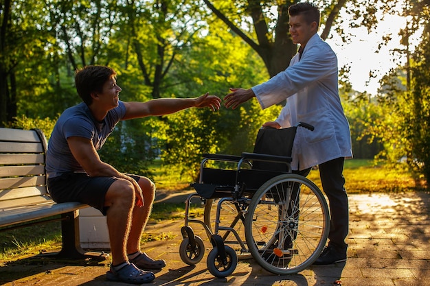 Joven doctor ayudando a un chico a ponerse de pie.