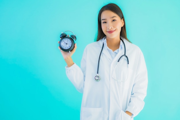 joven doctora asiática con reloj despertador