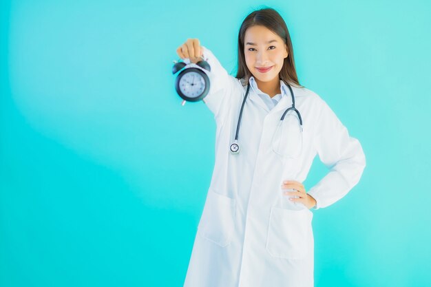 joven doctora asiática con reloj o alarma