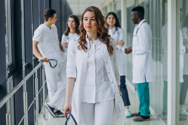 Joven doctora caminando por el pasillo del hospital