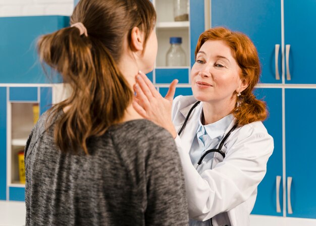 Joven doctora comprobando al paciente