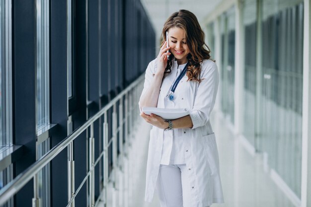 Joven doctora con estetoscopio en el hospital