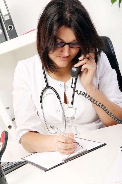 Joven doctora hablando por teléfono