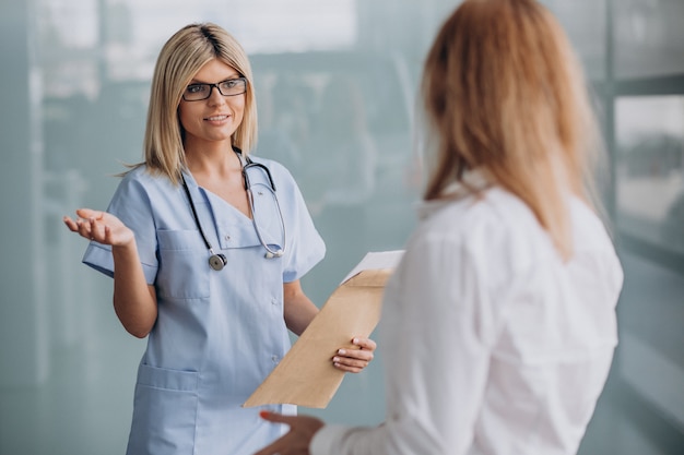 Foto gratuita joven doctora con paciente en clínica