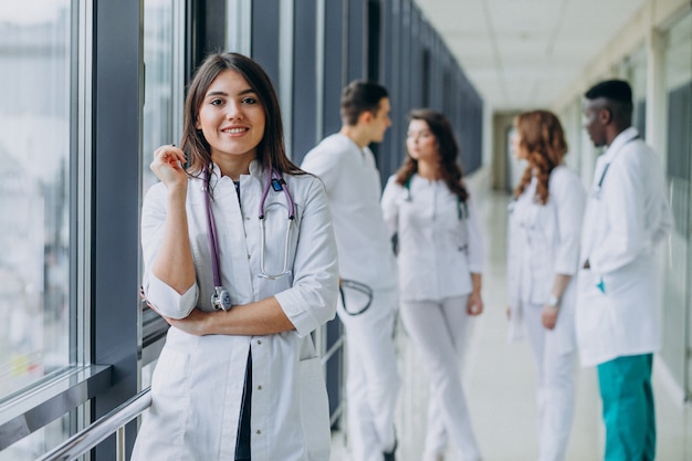 Joven doctora de pie en el pasillo del hospital