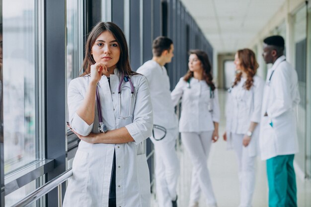 Joven doctora posando en el pasillo del hospital