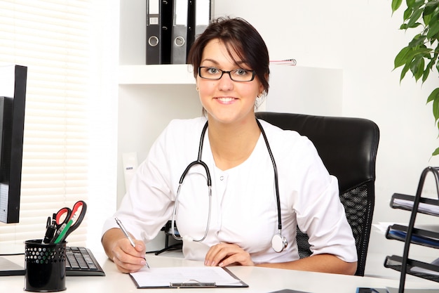 Foto gratuita joven doctora en su consultorio