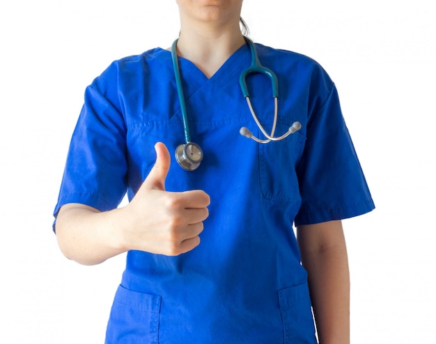 Joven doctora en un uniforme médico azul que muestra un gesto de pulgar hacia arriba