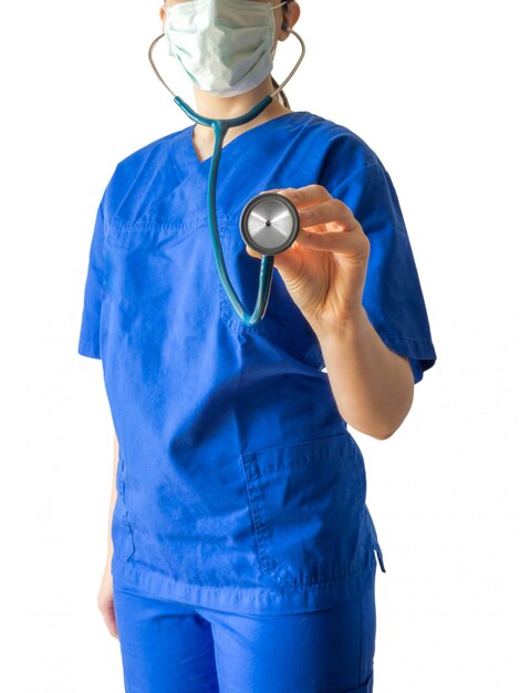 Joven doctora en un uniforme médico azul sosteniendo un estetoscopio aislado sobre un fondo blanco.