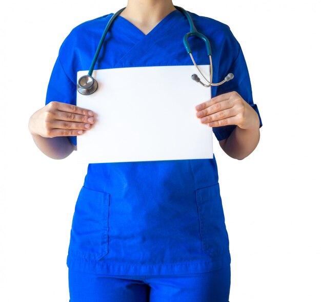 Joven doctora en un uniforme médico azul sosteniendo un libro blanco en blanco con un espacio de copia