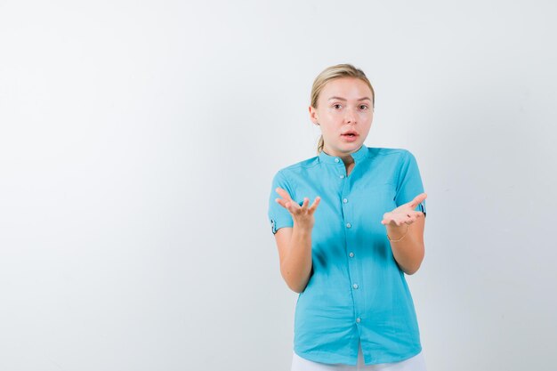 Joven doctora en uniforme médico, máscara manteniendo las manos de manera agresiva