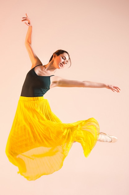 Joven e increíblemente bella bailarina baila en el estudio