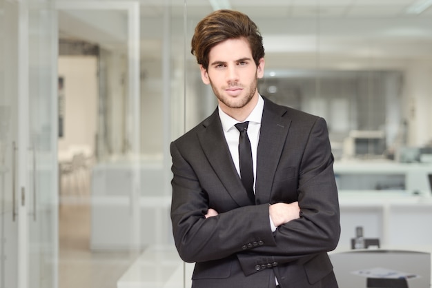 Foto gratuita joven ejecutivo con corbata y brazos cruzados