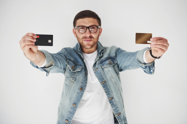Joven ejecutivo de negocios masculino guapo en vestimenta casual con una tarjeta de crédito en los bolsillos en blanco