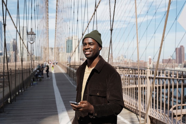 Foto gratuita joven elegante explorando un puente de la ciudad por sí mismo